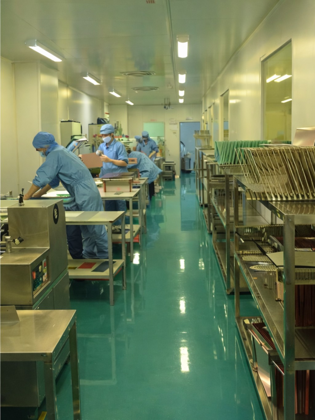 PCB cleanroom operator handling circuit boards in controlled manufacturing environment